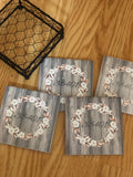 Four tile coaster set with a beautiful black coaster holder and  a 38401 zip code wood grain cotton ring monogram like wood look background.