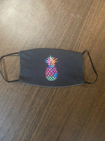 multi colored pineapple designed Face cover, with a black background and black backing and back ear loops face mask